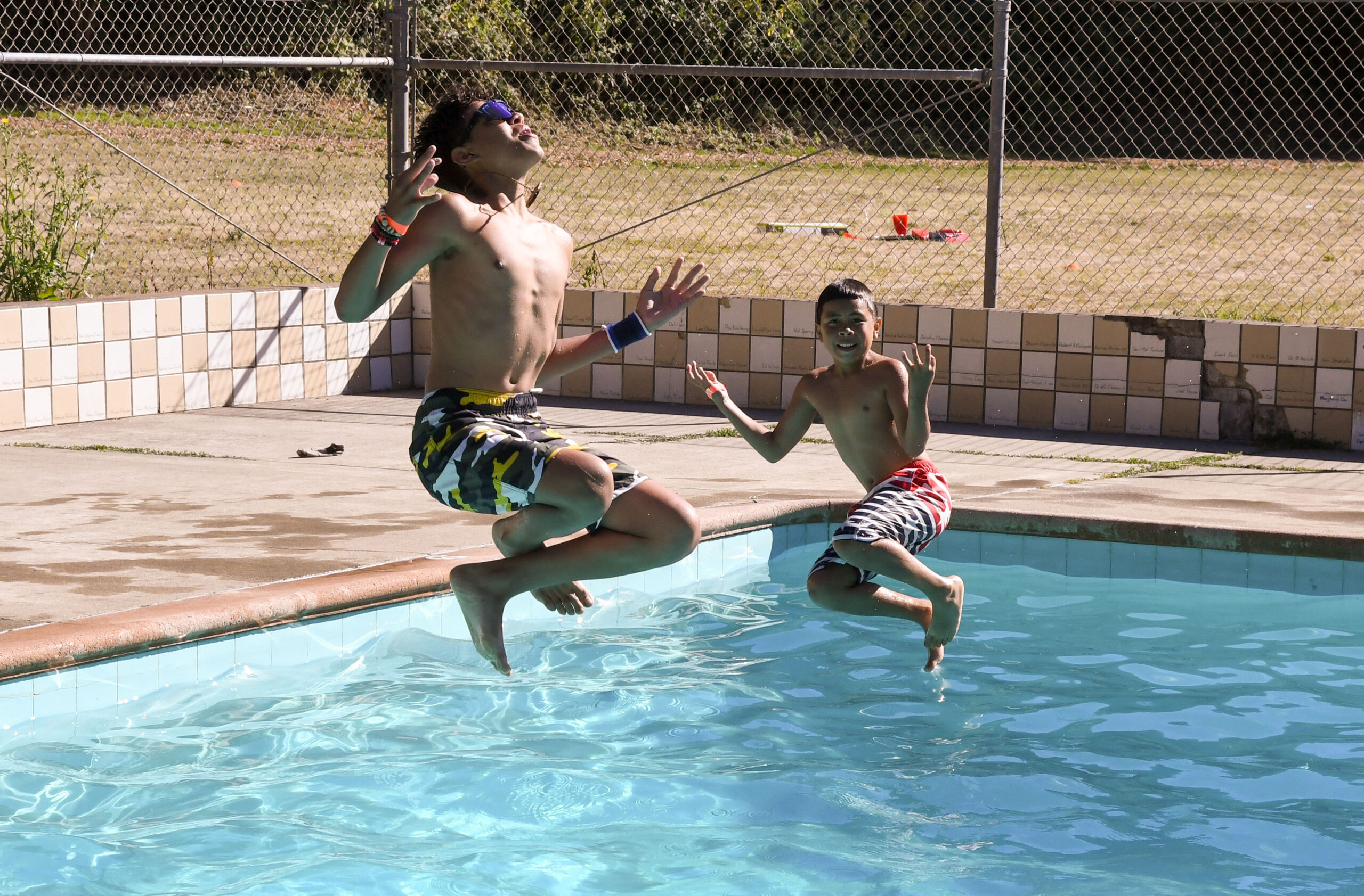 Campers jumping into the swimming pool